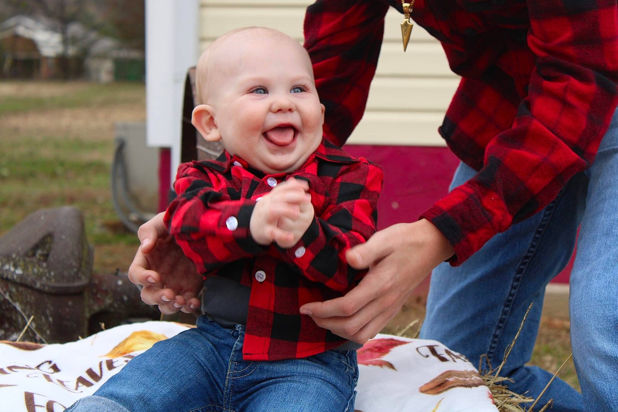 Clayton is registered to the contest to win money with this photo: baby, chair, child, christmas_eve, event, facial_expression, fun, happy, jeans, lap, leisure, pattern, person, plaid, plant, recreation, sitting, smile, tartan, toddler