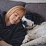Billi a rejoint le concours — aidez-le/la à gagner de superbes lots ! woman, dog, couch, sleeping, relaxation, indoor, pet, companion, cozy, rest, casual_clothing, hoodie, white_dog, black_and_white_dog, short_hair, comfort, nap, friendship, peaceful, home