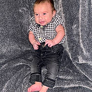 Gavin joined the competition — help win amazing prizes! baby, barefoot, blanket, casual_clothing, checkered_shirt, child, cozy, cute, feet, gray_background, happy, indoor, infant, jeans, person, portrait, sitting, small_hands, smiling, young