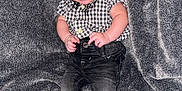 Gavin is registered to the contest to win money with this photo: baby, barefoot, blanket, casual_clothing, checkered_shirt, child, cozy, cute, feet, gray_background, happy, indoor, infant, jeans, person, portrait, sitting, small_hands, smiling, young