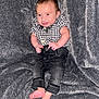 baby, barefoot, blanket, casual_clothing, checkered_shirt, child, cozy, cute, feet, gray_background, happy, indoor, infant, jeans, person, portrait, sitting, small_hands, smiling, young
