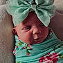 Maizley is registered to the contest to win money with this photo: baby, infant, newborn, baby_girl, swaddle, blanket, headband, bow, floral_pattern, closeup, face, cheeks, eyes, nose, pout, ear, soft_texture, pastel_colors, portrait, indoor