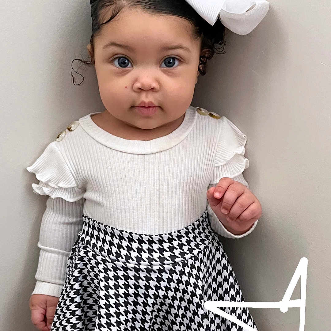 Kaveya is registered to the contest to win money with this photo: baby, blackhair, bodypart, clothing, dress, face, finger, hair, hand, head, miniskirt, person, photography, portrait, shorts, skirt, sleeve, standing, symbol, text