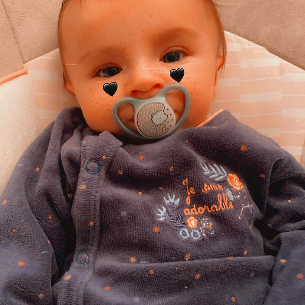 Mïa participe au concours pour gagner de l'argent avec cette photo : baby, blanket, bodypart, clothing, couch, face, finger, furniture, hand, head, jeans, knitwear, longsleeve, pants, person, photography, portrait, sleeve, sweater, toy