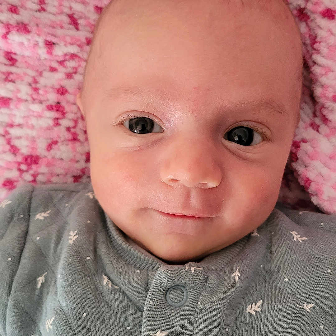 Gabin a rejoint le concours — aidez-le/la à gagner de superbes lots ! baby, blanket, buttoned_clothing, child, closeup, cozy, cute, eyes, face, gray_clothing, head, infant, lying_down, newborn, pink, portrait, skin, smile, soft_texture, warm