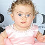 baby, child, curly_hair, blue_eyes, pink_dress, pearl_necklace, portrait, cute, innocent, tulle_skirt, infant, sitting, soft_lighting, closeup, young_child, person, fashion, studio_photo, background_text, expressionless