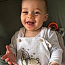 baby, child, smiling, happy, face, hands, white_clothing, overalls, bear_design, toy, colorful_toy, indoor, portrait, infant, cute, expression, skin, head, eyes, mouth