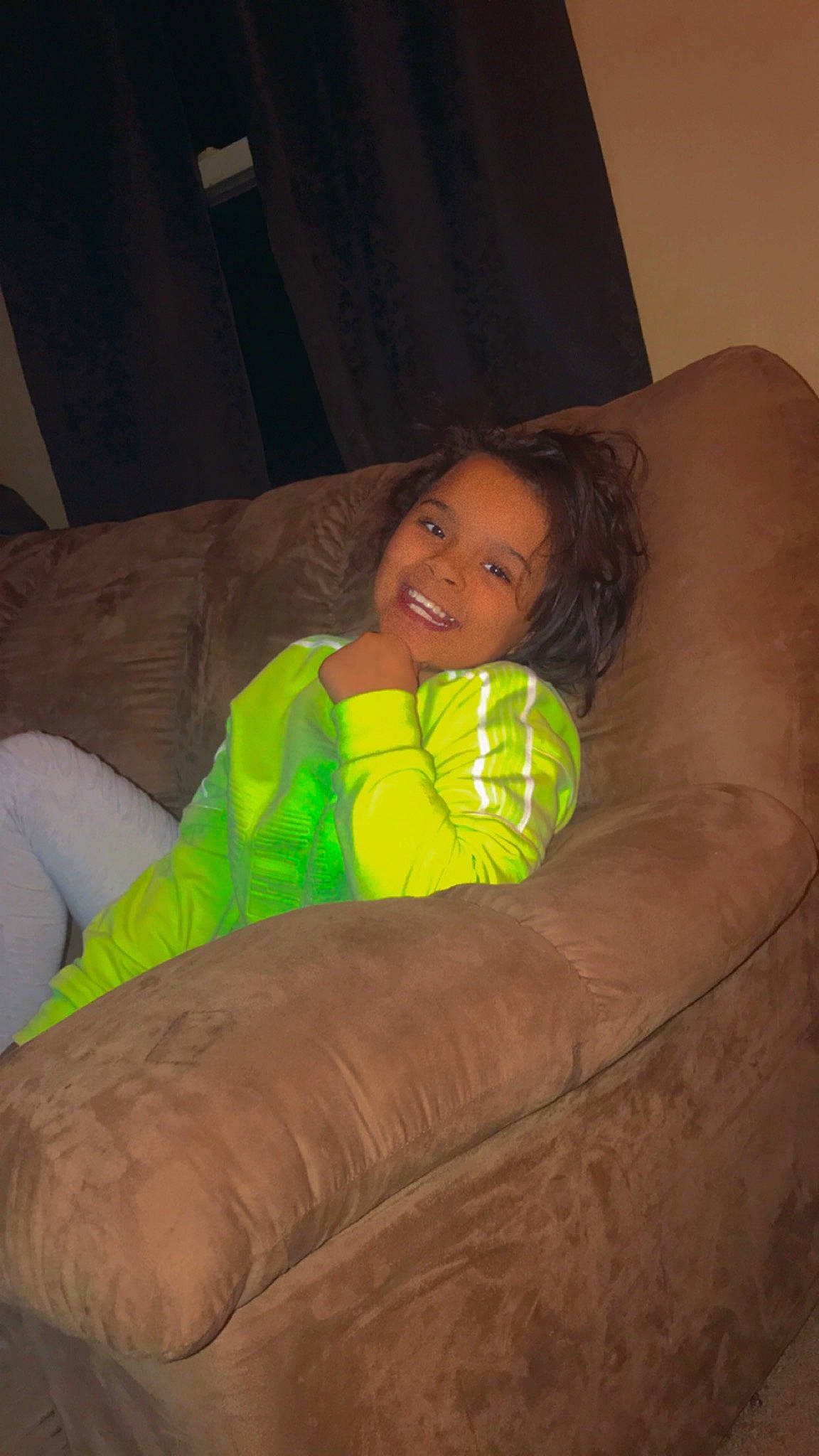 Miracle is registered to the contest to win money with this photo: ball, bean_bag, child, comfort, couch, eye, face, finger, flash_photography, fun, furniture, hair, head, human_leg, joy, leg, living_room, person, pillow, smile