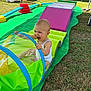 baby, child, clothing, colorful, crawling, fun, grass, green_mat, happy, infant, outdoor, person, plastic_toy, playground, playtime, smiling, summer, sunny, toy, tunnel