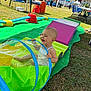 baby, chair, child, colorful, event, festival, fun, grass, happy, inflatable, outdoor, people, play_tunnel, playground, rainbow, smiling, sunny, table, tent, toy