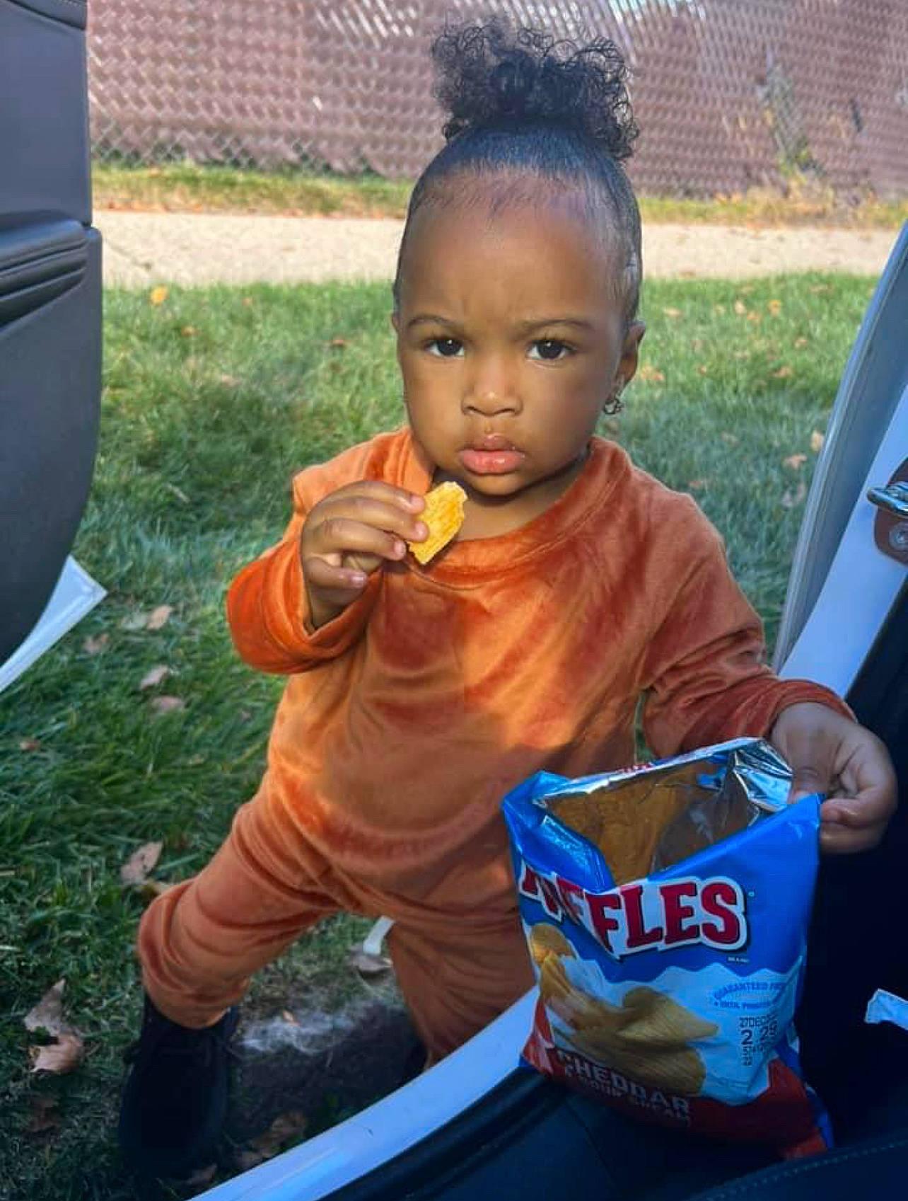 Zuri is registered to the contest to win money with this photo: child, comfort_food, cool, drink, fun, grass, happy, junk_food, person, plant, plastic, play, sitting, snack, soil, t_shirt, thumb, toddler, vehicle_door
