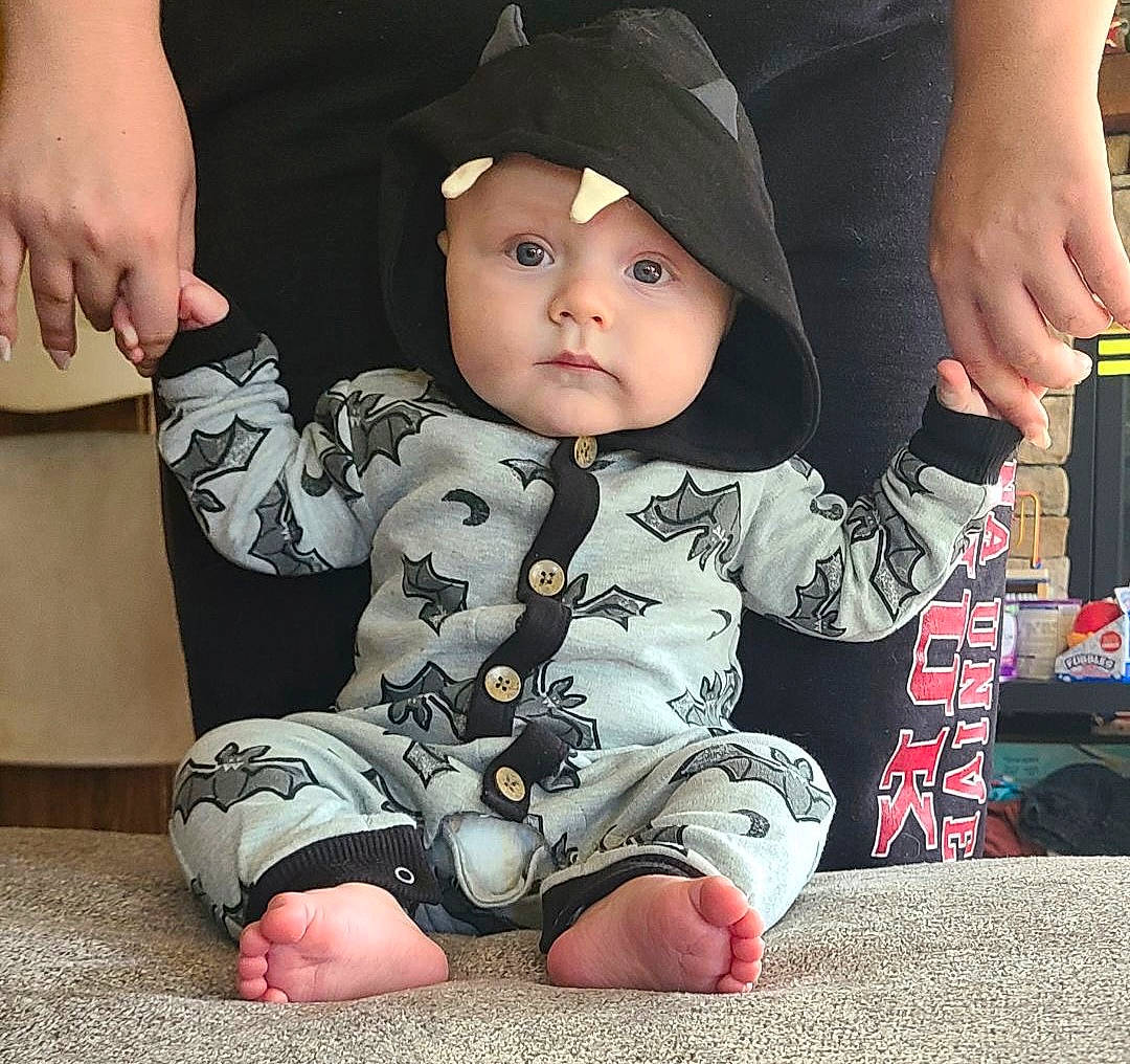 Riley is registered to the contest to win money with this photo: baby, baby_toddler_clothing, barefoot, cap, child, collar, comfort, fashion_accessory, finger, flooring, foot, fun, hand, happy, headwear, human_leg, pattern, person, sitting, sleeve