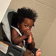 Jayceon joined the competition — help win amazing prizes! toddler, child, baby, car_seat, curly_hair, foot, sucking, indoor, wall, seatbelt, straps, portrait, cute, expression, curiosity, skin, barefoot, infant, young_child, sitting