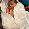 newborn, baby, sleeping, wrapped, blanket, soft, infant, peaceful, cute, face, hand, yellow_clothing, striped_blanket, resting, indoors, portrait, cozy, closeup, child, person