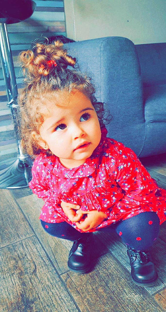 Ambre a rejoint le concours — aidez-le/la à gagner de superbes lots ! armrest, baby, baby_toddler_clothing, boot, cheek, child, child_model, couch, living_room, nose, person, pink, sitting, slipcover, toddler