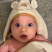 Charlotte joined the competition — help win amazing prizes! baby, towel, hood, face, eyes, expression, blanket, skin, infant, child, floor, wooden_floor, carpet, cute, indoor, portrait, person, soft_texture, wrapped, young