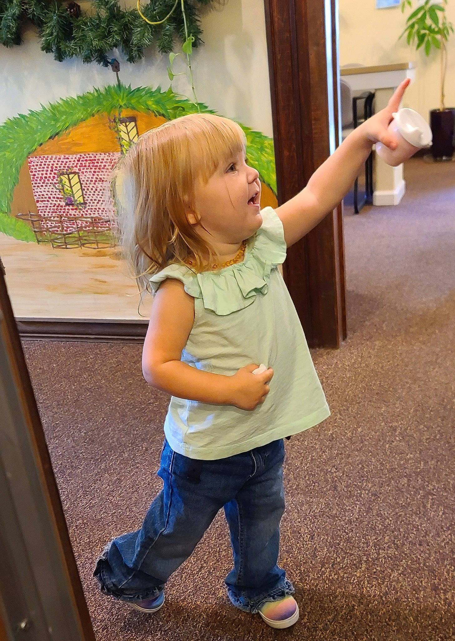 Amber is registered to the contest to win money with this photo: facial_expression, finger, fun, gesture, grass, green, happy, houseplant, jeans, joint, leg, leisure, nose, person, plant, shoulder, skin, standing, t_shirt, toddler