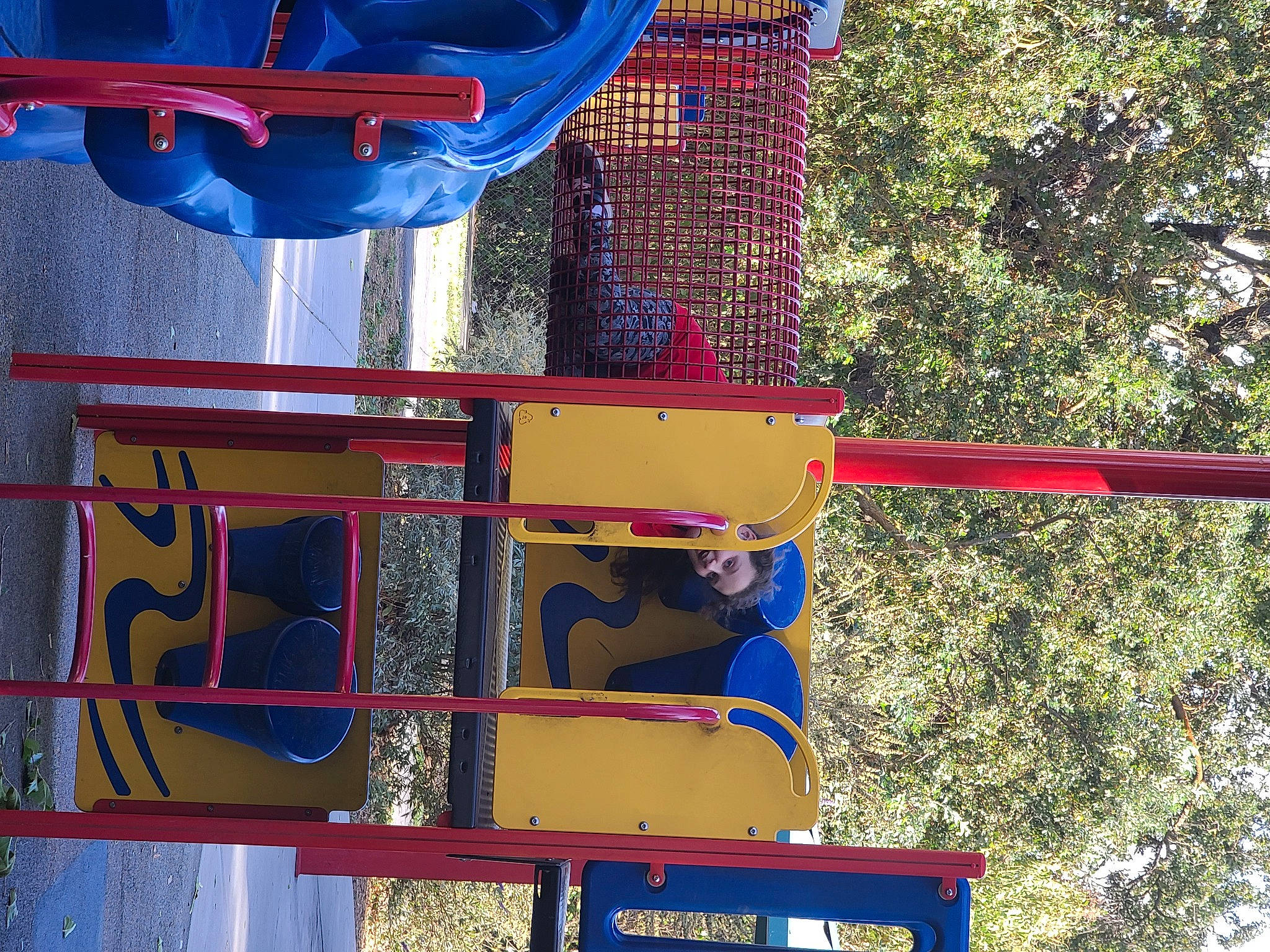 Scarlette is registered to the contest to win money with this photo: auto_part, automotive_exterior, blue, carmine, chute, city, electric_blue, fun, gas, leisure, machine, outdoor_play_equipment, person, playground, recreation, red, tire, tree, vehicle, wheel