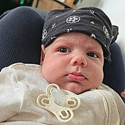Matthew participe au concours pour gagner de l'argent avec cette photo : baby, infant, pacifier, headscarf, clothing, face, person, indoors, curious, closeup, cheeks, white_outfit, lap, plant, furniture, skin, expression, human, portrait, resting