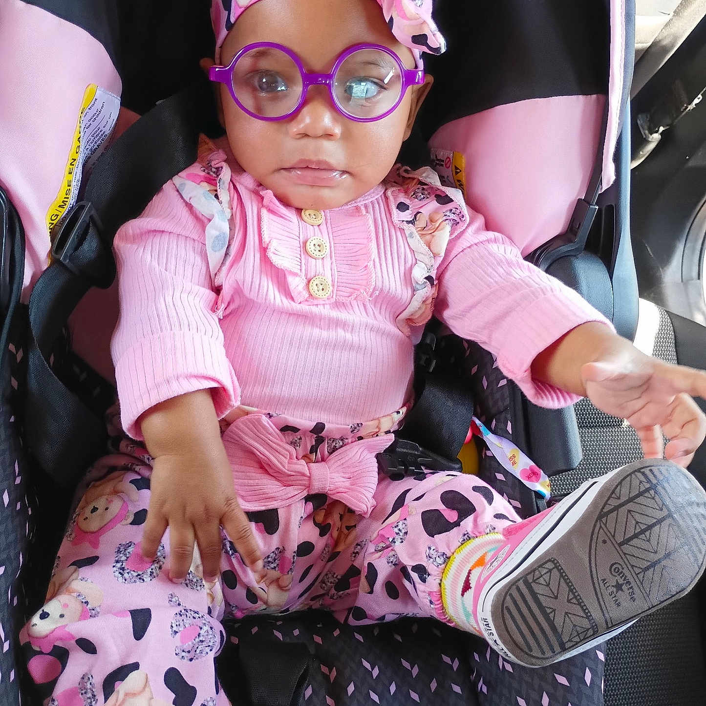 Miracle Cheatham is registered to the contest to win money with this photo: accessory, baby, car_interior, car_seat, casual, child, cute, expression, fashion, footwear, glasses, headband, infant, one_person, pink_clothing, playful, portrait, seatbelt, sitting, socks