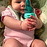 baby, infant, child, onesie, pink_clothing, hands, face, pacifier, blanket, mesh_feeder, sitting, closeup, cute, chubby, indoor, soft_texture, skin, toy, expression, holding