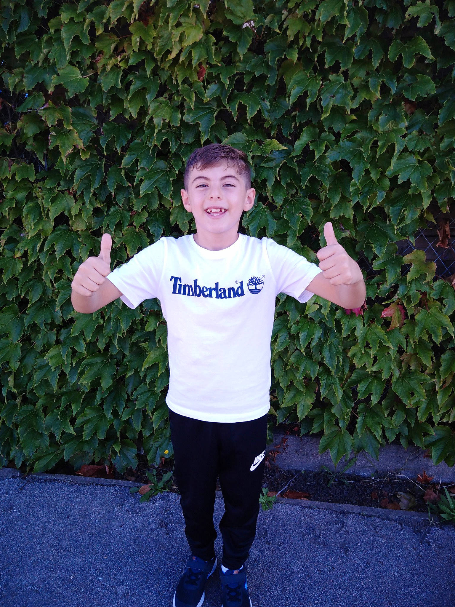 Gabriel participe au concours pour gagner de l'argent avec cette photo : child, electric_blue, eye, fun, gesture, grass, happy, joy, leg, leisure, people_in_nature, person, plant, sleeve, smile, sportswear, sweatpant, t_shirt, thumb, toddler