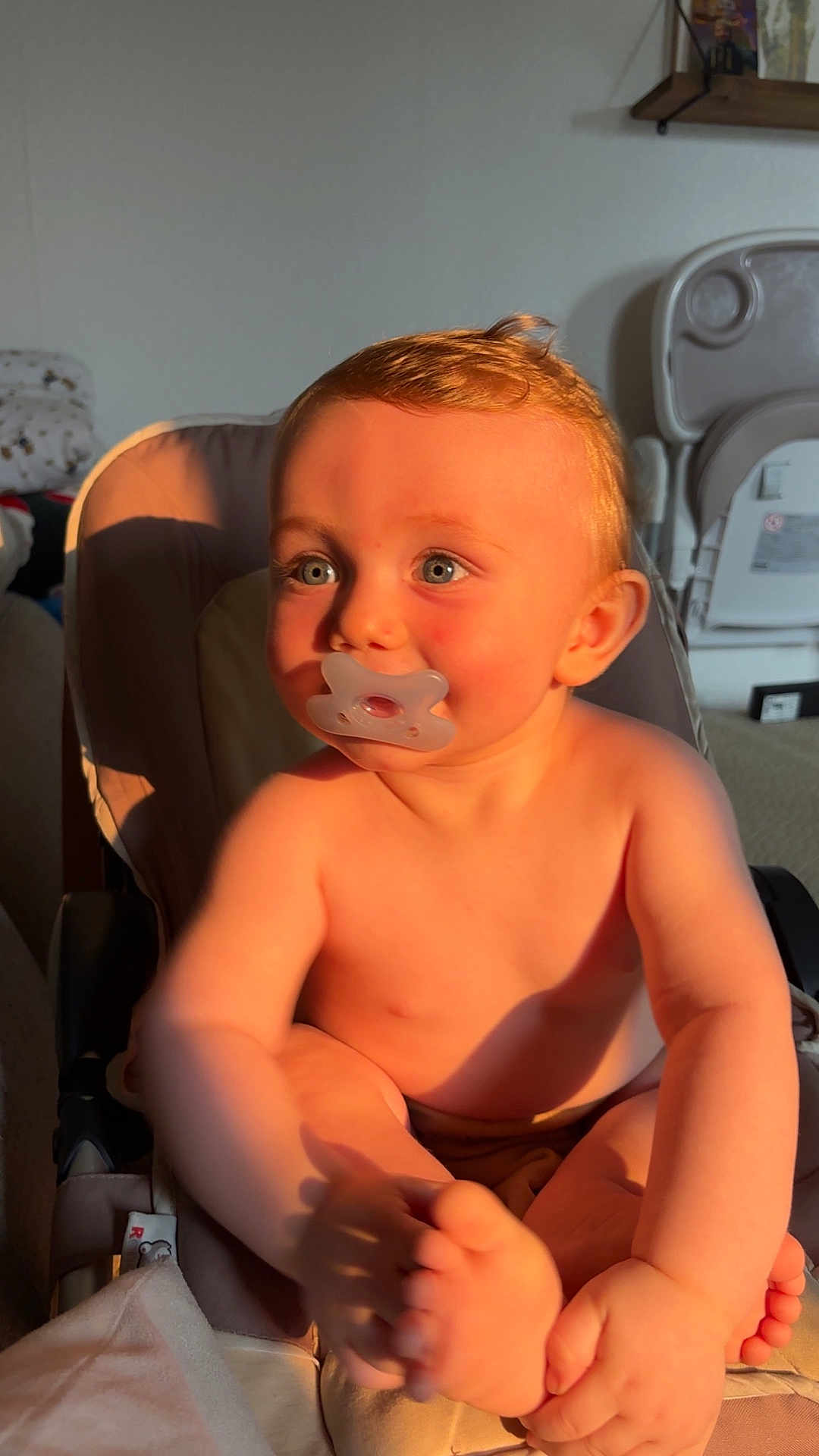 Lyzio a rejoint le concours — aidez-le/la à gagner de superbes lots ! baby, pacifier, child, infant, highchair, sunlight, indoor, curly_hair, blue_eyes, skin, hand, foot, face, cheek, furniture, sitting, toy, room, shelf, cozy