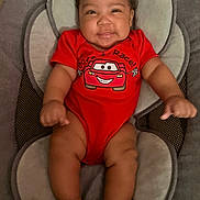Chozyn is registered to the contest to win money with this photo: arms, baby, car_graphic, child, clothing, comfort, cushioned_chair, cute, expression, happy, head, indoors, infant, legs, person, portrait, red_onesie, seated, skin, smile