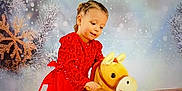 Ylonna a rejoint le concours — aidez-le/la à gagner de superbes lots ! child, girl, red_dress, plush_toy, toy_horse, winter, snowflakes, holiday, festive, indoor, portrait, smiling, cute, playful, decorations, background, young_child, happy, celebration, holiday_theme
