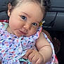 adorable, baby, car_interior, child, clothing, curly_hair, cute, dress, face, floral_pattern, hair, hand, holding, infant, looking, pacifier_clip, portrait, seat, sitting, skin