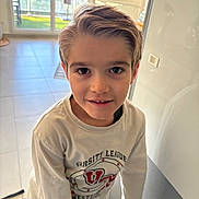 Mathys a rejoint le concours — aidez-le/la à gagner de superbes lots ! child, boy, indoor, portrait, smiling, casual_clothing, long_sleeve_shirt, hair, face, eyes, tile_floor, balcony, window, daylight, home_interior, wall, light_switch, young, person, standing