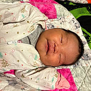 Addison is registered to the contest to win money with this photo: newborn, baby, sleeping, onesie, quilt, patterned_clothing, pink, green, gray, face, infant, child, soft_texture, cute, peaceful, closed_eyes, rest, portrait, cozy, bed