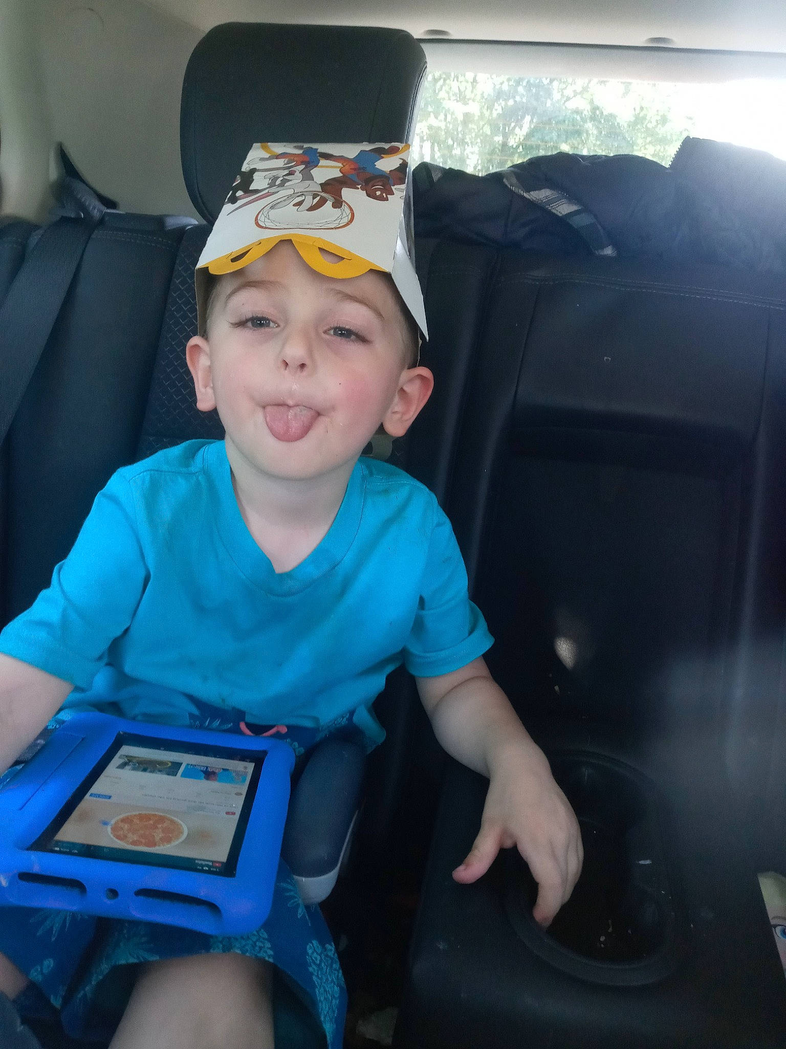 Junior is registered to the contest to win money with this photo: auto_part, automotive_design, automotive_exterior, baseball_cap, cap, car_seat, child, electric_blue, family_car, fun, hat, headwear, human_body, lap, motor_vehicle, person, smile, steering_wheel, t_shirt, toddler