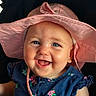 baby, child, smile, blue_eyes, pink_hat, dress, floral_pattern, happy, face, portrait, cute, infant, clothing, headwear, young_child, sitting, indoors, closeup, cheerful, person
