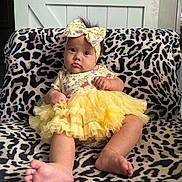Journey is registered to the contest to win money with this photo: baby, infant, child, tutu, yellow, headband, bow, leopard_print, blanket, sitting, indoors, curious, cute, soft_lighting, expression, foot, hand, face, clothing, portrait