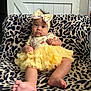 baby, infant, child, tutu, yellow, headband, bow, leopard_print, blanket, sitting, indoors, curious, cute, soft_lighting, expression, foot, hand, face, clothing, portrait
