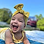 Ivory is registered to the contest to win money with this photo: baby, smiling, yellow_bow, headband, outdoor, blue_sky, towel, happy, infant, child, cute, portrait, sunny, grass, clothing, skin, hands, face, nature, daytime