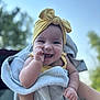 baby, smiling, towel, headband, yellow, outdoor, sky, happy, cute, infant, hand, face, child, portrait, person, expression, nature, daylight, holding, playful