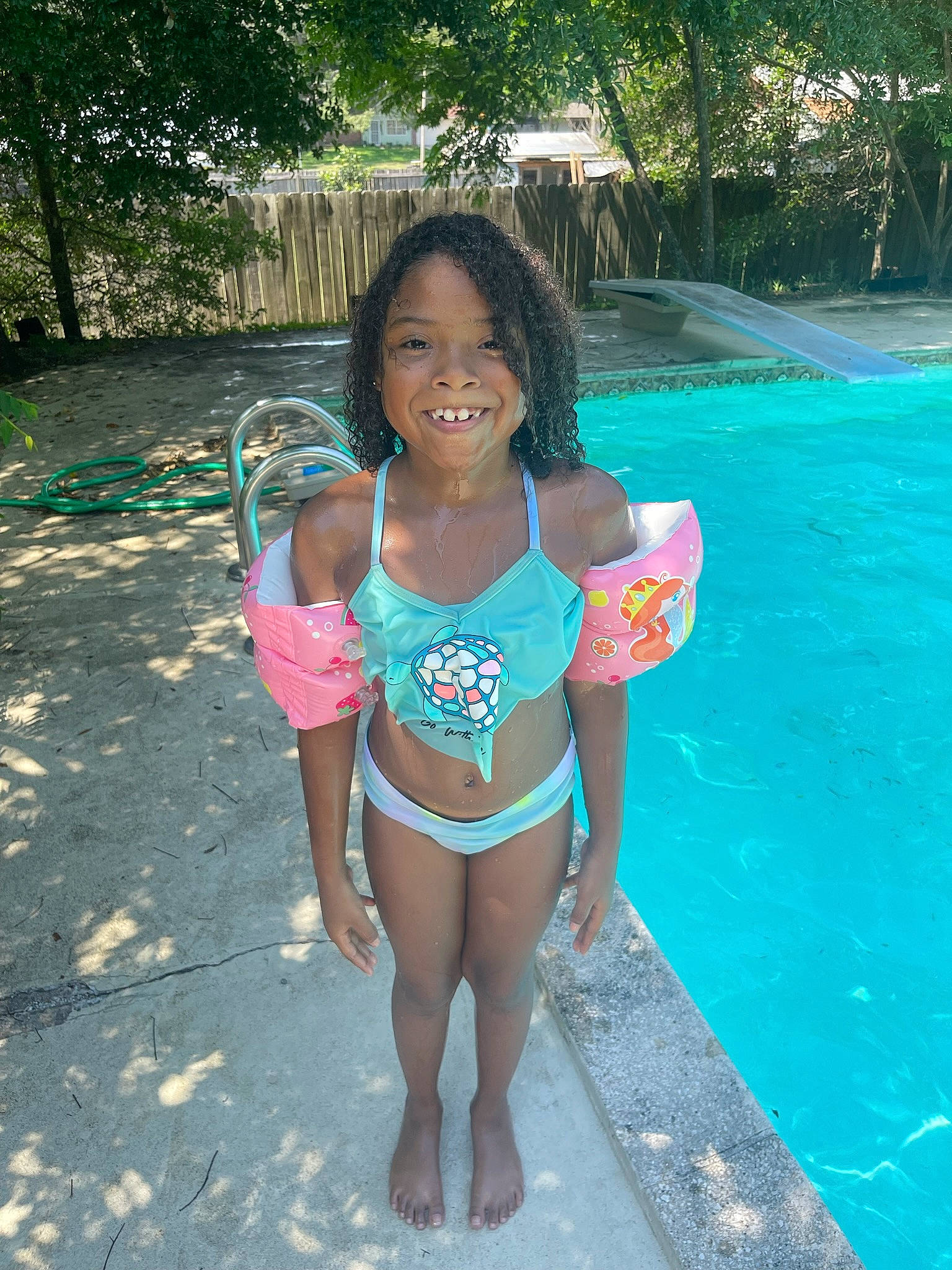 Alyssa is registered to the contest to win money with this photo: aqua, beauty, black_hair, fun, happy, human_leg, joy, leisure, person, recreation, smile, summer, swimming_pool, swimsuit_top, swimwear, thigh, toddler, tree, trunk, undergarment