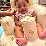 baby, child, smile, curly_hair, infant, baby_chair, teddy_bear_pattern, hand, foot, indoors, furniture, cute, happy, person, soft_toys, plush, comfort, pink_clothing, seat, playful