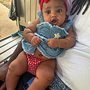 Keani joined the competition — help win amazing prizes! baby, child, person, headband, red_bow, denim_dress, outdoor, bench, lap, hand, car_key, curious_expression, skin, legs, clothing, casual, summer, sunlight, portrait, closeup