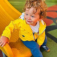 Swan participe au concours pour gagner de l'argent avec cette photo : toddler, child, yellow_jacket, curly_hair, playground, slide, smile, outdoor, casual_clothing, blue_pants, play_area, happy, young_child, sitting, daylight, play_equipment, footwear, fun, park, cute