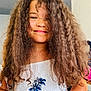 Victoire a rejoint le concours — aidez-le/la à gagner de superbes lots ! child, girl, smile, curly_hair, portrait, indoor, white_top, blue_print, palm_tree, casual_clothing, happy, young, person, face, hair, standing, closeup, natural_light, skin, candid