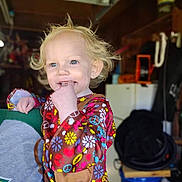 Meadow is registered to the contest to win money with this photo: baby, blonde, bodypart, clothing, coat, dress, face, fashion, finger, formalwear, hair, happy, head, person, photography, plant, portrait, pottedplant, robe, smile