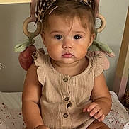 Sohana participe au concours pour gagner de l'argent avec cette photo : baby, bed, blanket, child, cute, hair_bow, indoors, infant, knitted_clothing, leopard_print, nursery, person, portrait, romper, serious_expression, sitting, skin, socks, soft_toys, wooden_rings