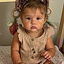 baby, bed, blanket, child, cute, hair_bow, indoors, infant, knitted_clothing, leopard_print, nursery, person, portrait, romper, serious_expression, sitting, skin, socks, soft_toys, wooden_rings