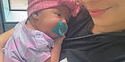 Rym a rejoint le concours — aidez-le/la à gagner de superbes lots ! baby, woman, pacifier, headband, window, indoor, smile, holding, clothing, pink, black_shirt, shorts, person, portrait, child, cute, young, face, human, casual