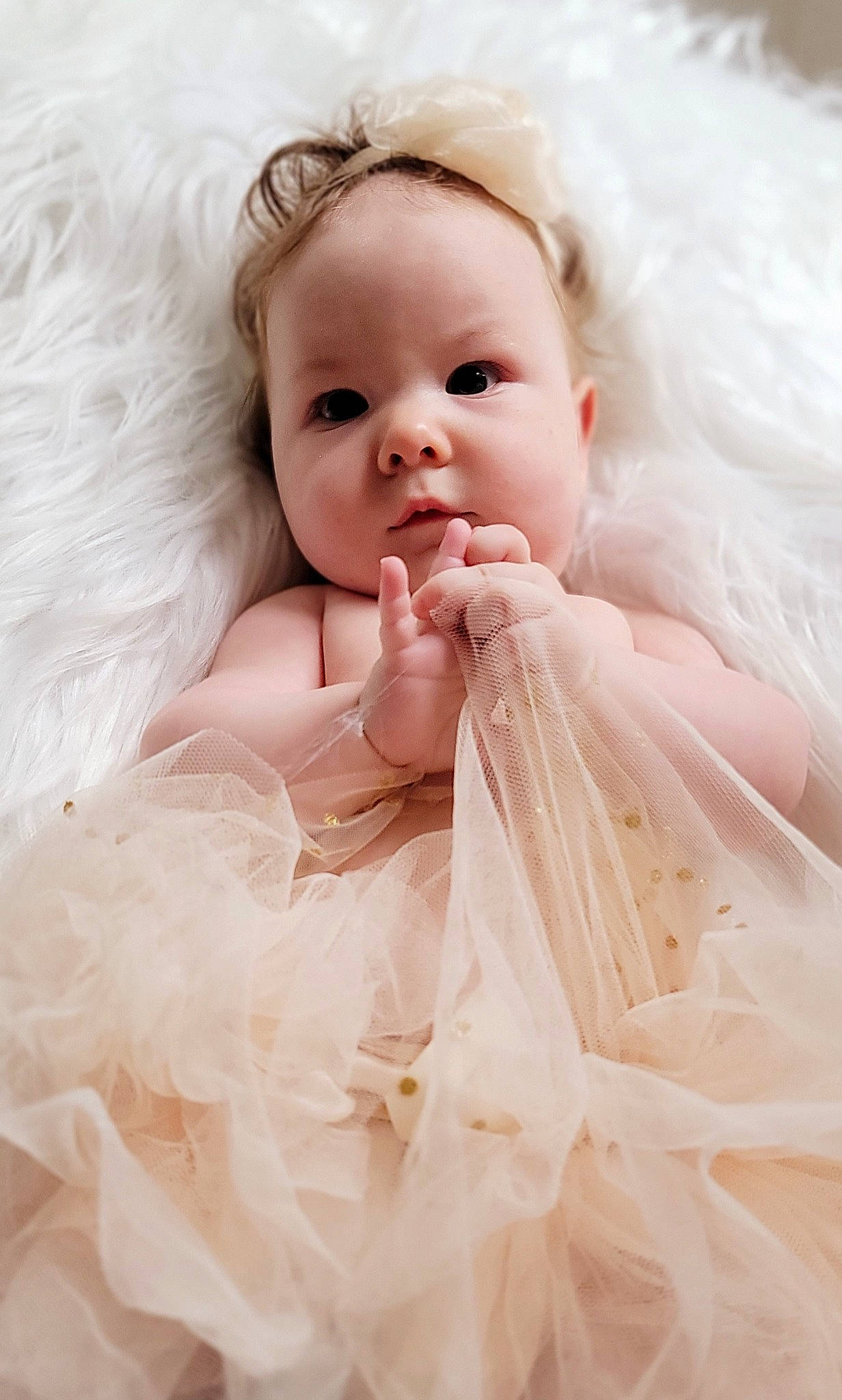 Mystic is registered to the contest to win money with this photo: arm, baby, baby_toddler_clothing, bridal_accessory, child, dress, embellishment, flash_photography, gesture, hand, happy, headpiece, iris, linens, person, pink, skin, sleeve, smile, textile