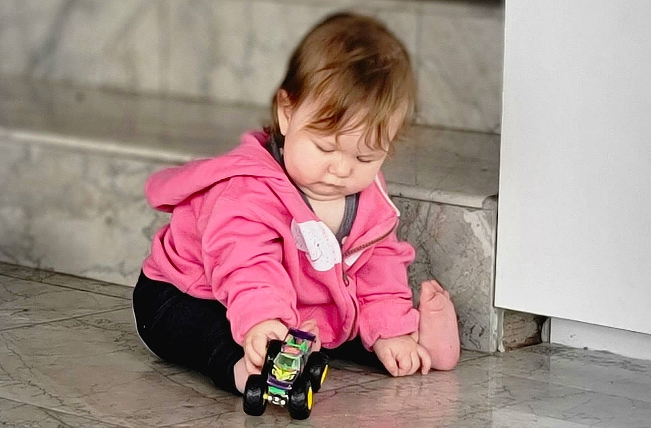 Mystic is registered to the contest to win money with this photo: baby, baby_toddler_clothing, cheek, child, crawling, flooring, fun, grass, happy, magenta, pattern, person, pink, play, portrait_photography, sitting, skin, smile, toddler, toy