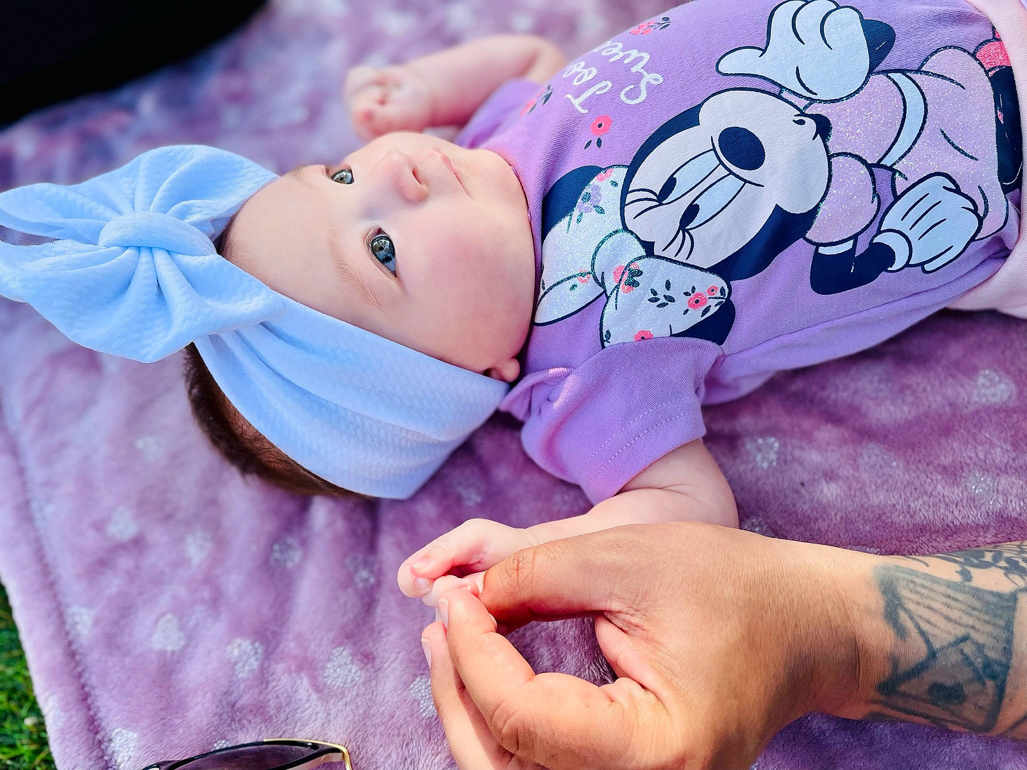 April joined the competition — help win amazing prizes! baby, baby_toddler_clothing, child, face, finger, gesture, grass, happy, hat, headwear, human_body, nail, pattern, people_in_nature, person, pink, plant, purple, skin, sleeve